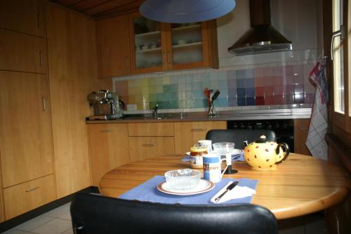 阿德尔博登伯格多尔公寓的厨房配有一张带蓝桌布的木桌