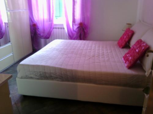 韦内雷港丽布塔公寓的一间卧室配有一张带粉红色窗帘的大床