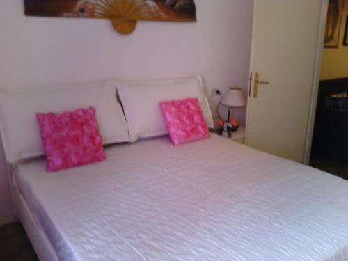 韦内雷港丽布塔公寓的一间卧室配有带粉红色枕头的床。