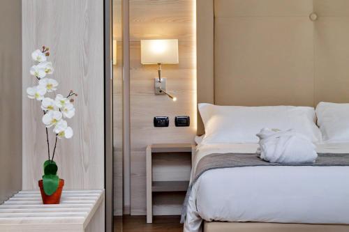 米兰Duomo Hotel & Apartments的一间卧室配有床和白色花瓶