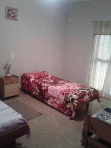 特尔马斯德里奥翁多Residencial Guadalupe的一间卧室配有一张带红色毯子的床