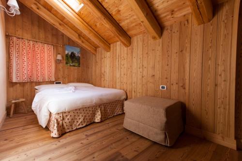 尚波吕克L' Aroula Rooms & Restaurant的木制客房内的一间卧室,配有一张床