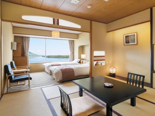 宫津市天野桥立日式旅馆的酒店客房设有一张床铺、一张桌子和一间卧室。
