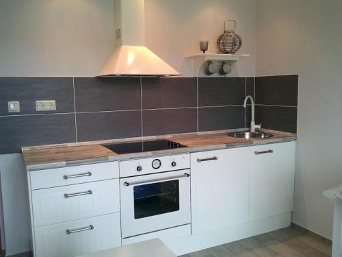 乌埃克尔明德Sealounge 239的厨房配有白色橱柜、炉灶和水槽。