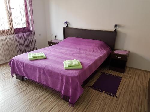 弗拉涅S&G Apartment的一间卧室配有一张紫色床和两条毛巾