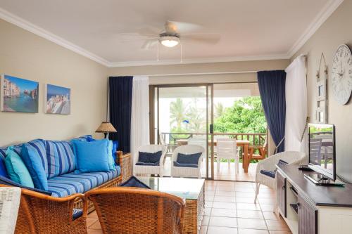 巴利托La Pirogue 19的一间带蓝色沙发的客厅和一个阳台