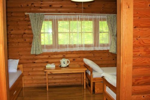 饭能市Shomarutoge Garden House的小木屋内的房间设有两张床和一个窗户