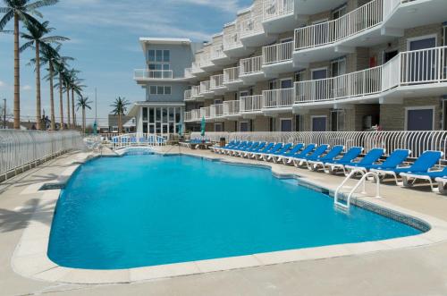 威尔伍德克拉斯特夏利马尔度假酒店的一座游泳池位于酒店前,配有躺椅