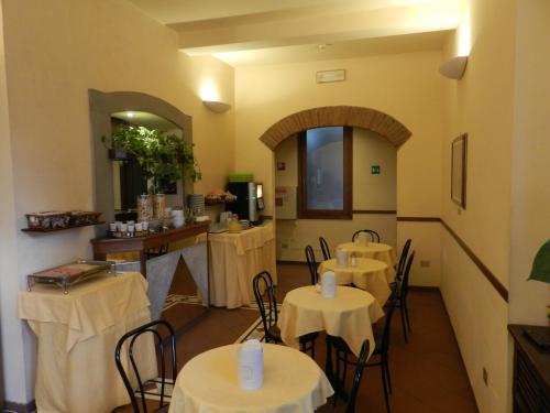 佛罗伦萨莫妮卡酒店的一间在房间内配有桌椅的餐厅