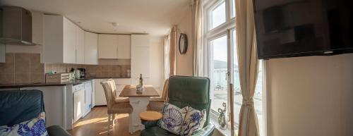 托特兰Garden Apartment, 2 Pilots Point的厨房配有桌椅和窗户。