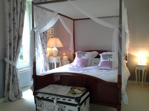 Saint-Philbert-de-BouaineGUTKOWSKI Jacqueline的一间卧室配有一张带紫色枕头的天蓬床