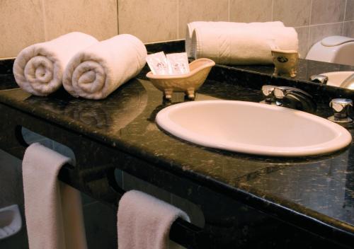 皮里亚波利斯里卡迪酒店的浴室柜台配有白色水槽和毛巾