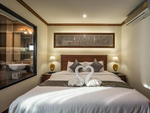清迈兰纳树精品酒店的卧室内床边的两只白色天鹅
