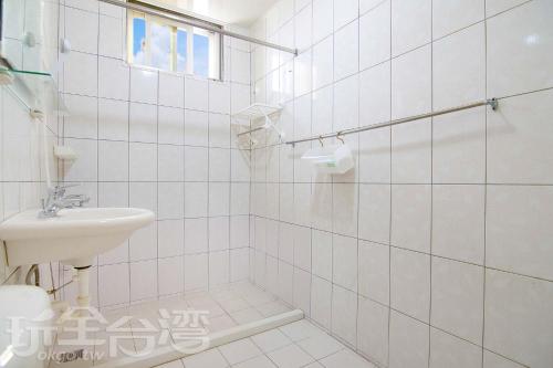 马公澎湖香亭民宿的白色瓷砖浴室设有水槽和卫生间