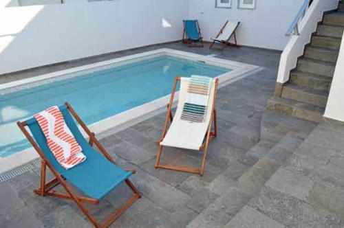 邦巴拉尔Alojamento Charme的游泳池旁的两把椅子