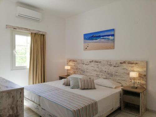 库基尼坎尼奥Evina Rooms & Suites的白色的卧室设有床和窗户