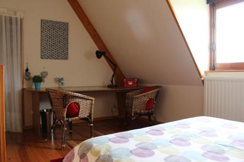 圣加蒂安代布瓦Gîte Pressoir Armand的卧室配有一张床、一张桌子和椅子
