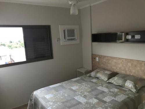 奥林匹亚Apartamento Villagio的一间卧室设有一张床和一个窗口