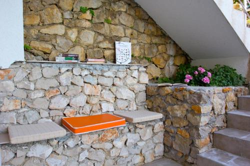 乌尔齐尼Apartments Gran Sasso的坐在石墙上的橙色长凳