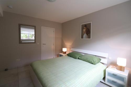 迪尔森-斯托科姆Stefjes Holiday Home的一间卧室配有一张带绿床单的床和两盏灯。