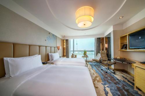 临沂市临沂鲁商铂尔曼大酒店的酒店客房设有两张床和电视。