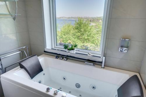 布罗艾厄Fjordhuset的带窗户的浴室内的白色大浴缸