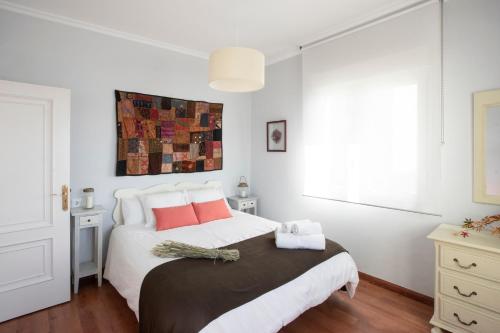 坎巴多斯Vivienda O Pombal的白色卧室配有一张带红色枕头的大床