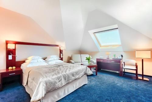 什切青阿奇姆酒店的一间卧室配有一张床、一张书桌和一个窗户。