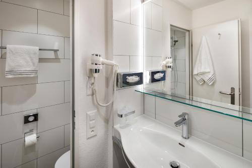 蒙特卡罗索Hotel Bellinzona Sud Swiss Quality的白色的浴室设有水槽和镜子