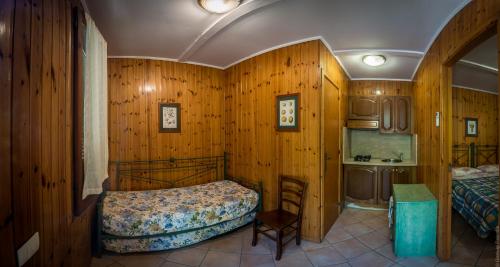 索伦托努毕德阿祯多营地的一间卧室设有木墙、一张床和一个水槽