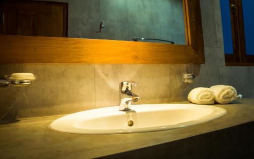 GiriullaRoshara Nalla的浴室内的盥洗盆,配有镜子和毛巾