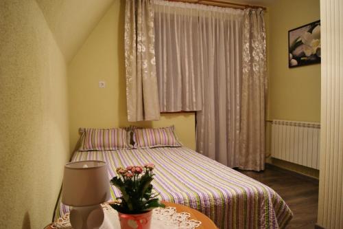 涅兹卡城堡Pokoje u Kordeckich的一间卧室配有一张床和一张鲜花桌子