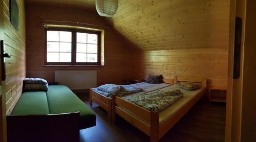 乌伊索维Pensjonat Danielka的小木屋内一间卧室,配有两张床