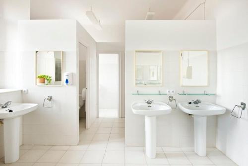 帕拉弗鲁赫尔Alberg Solidança Hostel的白色的浴室设有两个盥洗盆和镜子