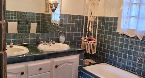 胡安莱潘Villa l'Air du temps的绿色瓷砖浴室设有两个盥洗盆和一个浴缸