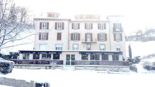 塞尔河畔维克Hôtel St Joseph的前面有大雪的建筑