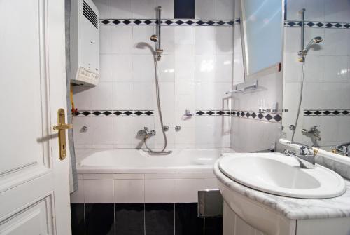 萨拉热窝住宅旅舍的带浴缸、水槽和浴缸的浴室