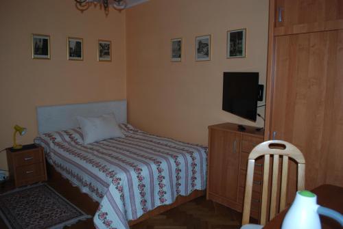 格丁尼亚Homestay Kapitańska 9的一间小卧室,配有一张床和电视