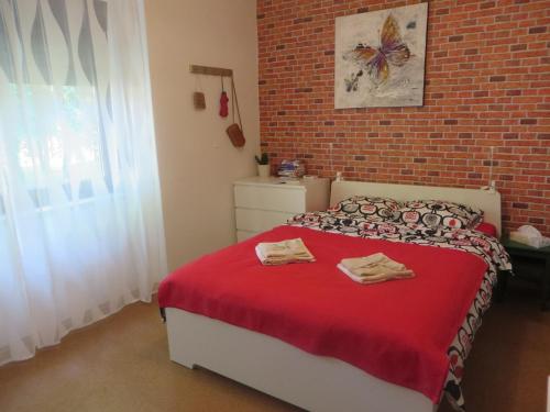 ZačretjeApartment Lucia的一间卧室配有一张红床单和砖墙床