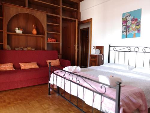 比萨B&B Colombo的一间卧室配有一张床和一张红色的沙发
