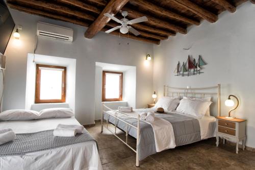加夫里翁Gavrion's Nest - Premium Cycladic Studio的一间卧室配有两张床和吊扇
