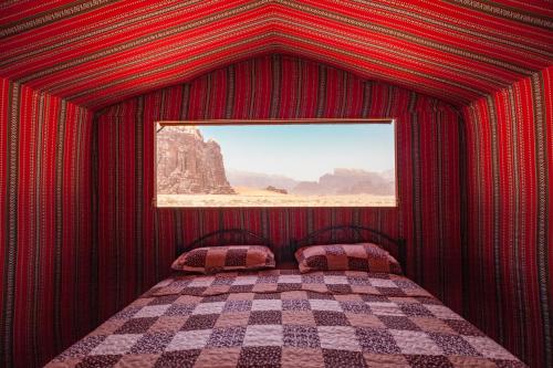 瓦迪拉姆Arabian Nights的红色的房间,设有一张带窗户的床
