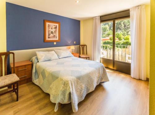 阿尔内迪略Hotel Parras Arnedillo的一间卧室配有一张蓝色墙壁和窗户的床