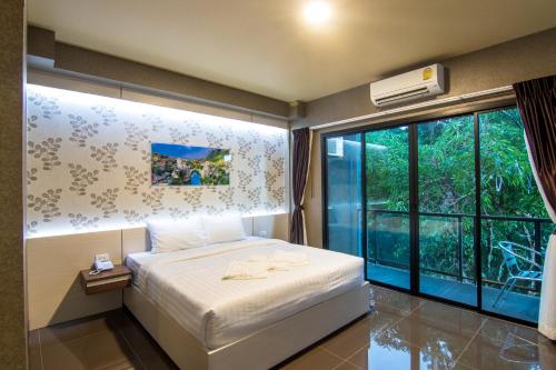 乌隆他尼PSG Hotel的一间卧室设有一张床和一个大窗户