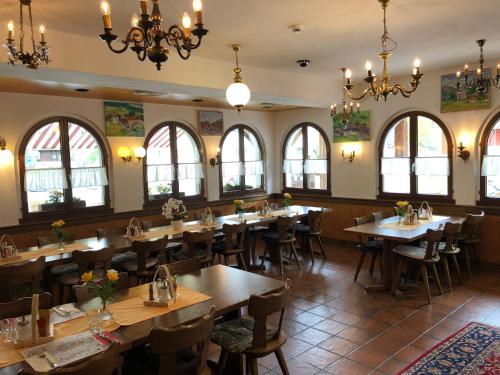 乌尔里兴瓦尔泽酒店的餐厅设有木桌、椅子和窗户。