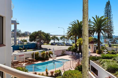 亚历山德拉岬角亚历克斯黑德兰海滨公寓的享有带游泳池和棕榈树的度假村的景致