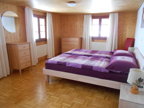 黑吉斯维尔奥伯提非公寓式酒店的一间卧室配有一张带紫色床单和窗户的床。