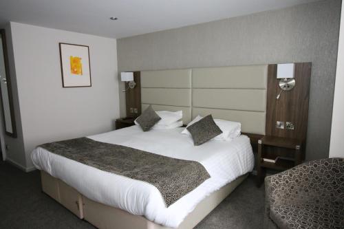 威灵堡雌鹿酒店的酒店客房带一张大床和一把椅子