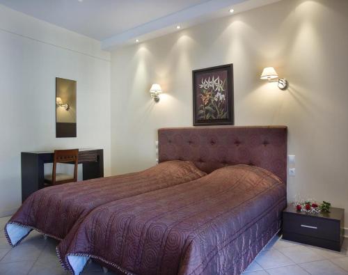 纳弗帕克托斯普拉扎酒店的一间卧室配有一张大床和红色的床罩