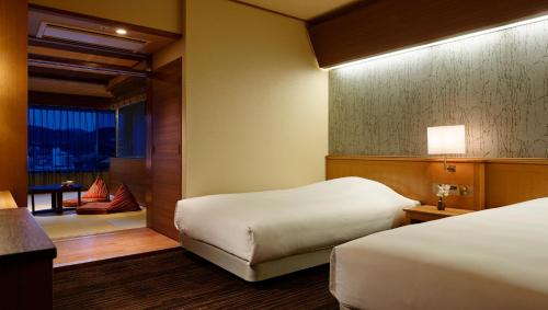伊东拉佛蕾俱乐部伊东温泉日式旅馆(Laforet Ito Onsen Yunoniwa)的酒店客房设有两张床和窗户。